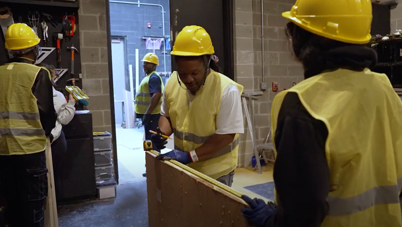 Modal Image Opens to lightbox video- A CEJA participant wearing reflective vests while holding a tape measure