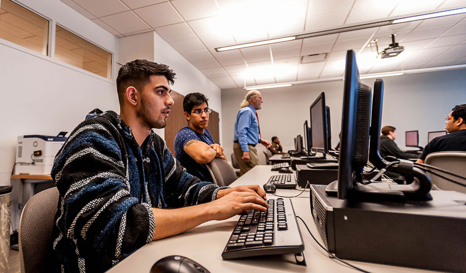 student typing at a computer