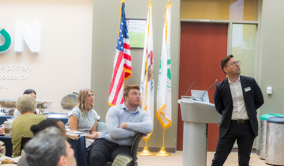 two attendees look at a presentation screen in front of the room